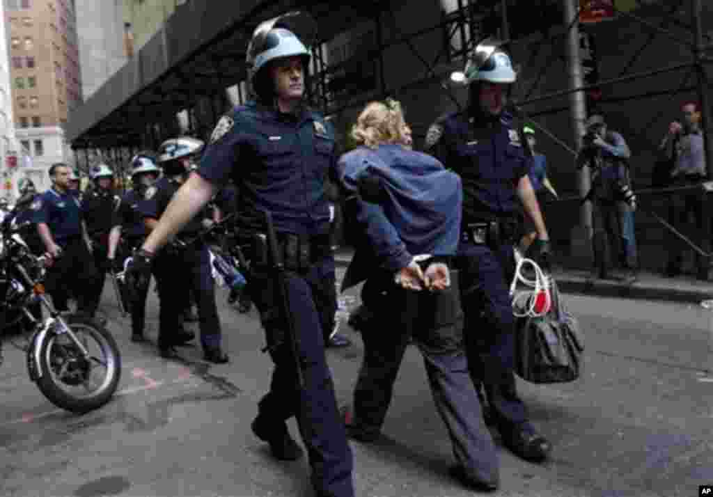 Police officers take away a protester during an Occupy Wall Street march at the New York Stock Exchange in New York, September 17, 2012.