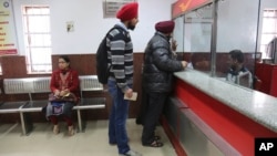 Warga India menukarkan lembaran uang lama yang ditarik pemerintah di sebuah kantor pos di pinggiran kota Jammu, India, 29 Desember 2016. (AP Photo/Channi Anand) 