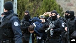 Kosovo police escort Marko Djuric a Serb official to a police station in Kosovo capital Pristina after he was arrested in northern Kosovo town of Mitrovica, Monday, March 26, 2018. 