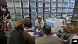Afghan election commission workers sort ballot papers for an audit of the presidential run-off votes at an election commission office in Kabul, Aug. 3, 2014. 