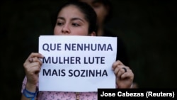 Manifestações em todo o mundo por Marielle Franco, mulher protesta em frente à embaixada do Brasil em El Salvador