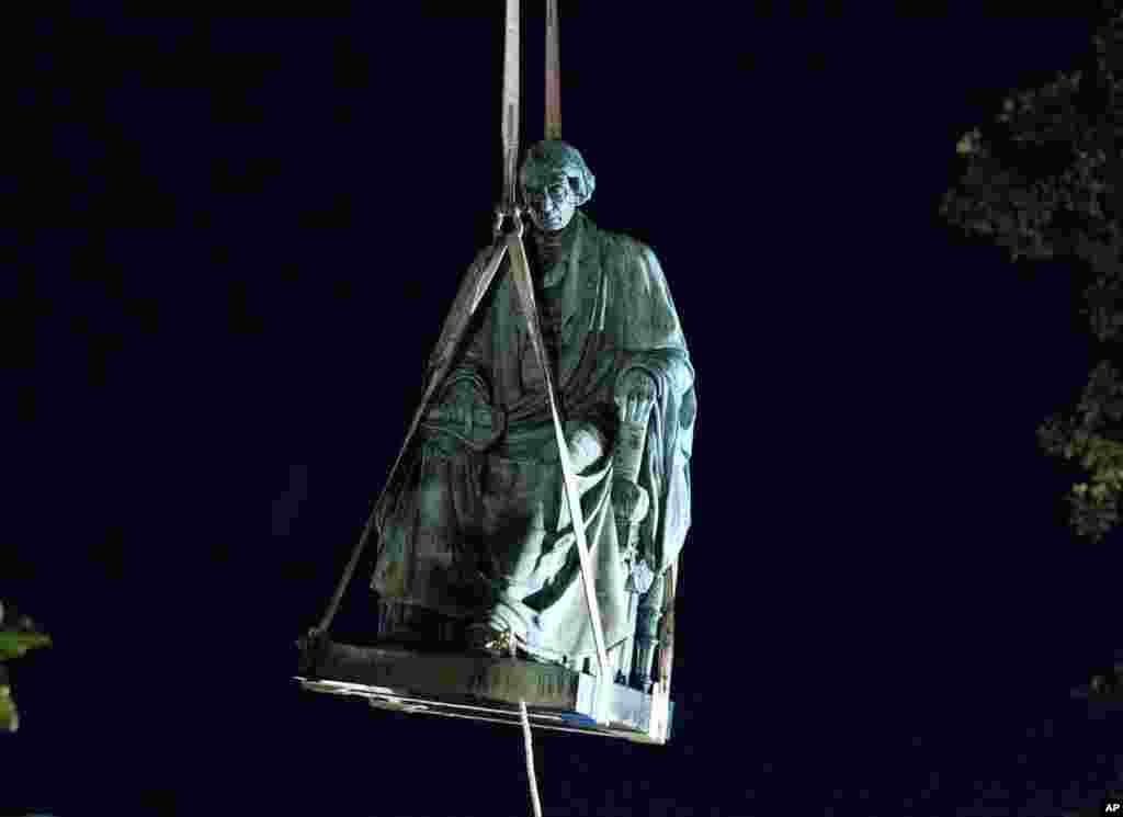 Workers use a crane to remove a monument to U.S. Supreme Court Chief Justice Roger Brooke Taney from outside the Maryland State House in Annapolis.