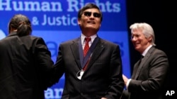 Chinese human rights activist Chen Guangcheng, center, smiles after being awarded the 2012 Tom Lantos Human Rights Prize by actor Richard Gere, right, on Capitol Hill in Washington, Jan 29, 2013.