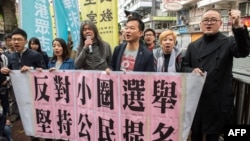 This picture taken March 26, 2017 shows activist Raphael Wong of the League of Social Democrats Raphael Wong (3rd R in rear) and Umbrella Movement protester Shiu Ka-chun (R) joining fellow protesters as they prepare to march in protest to the venue of the