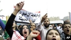 Syrian protesters shout anti-Assad slogans during a protest in front of the Arab League headquarters in Cairo, Egypt, November 12, 2011.