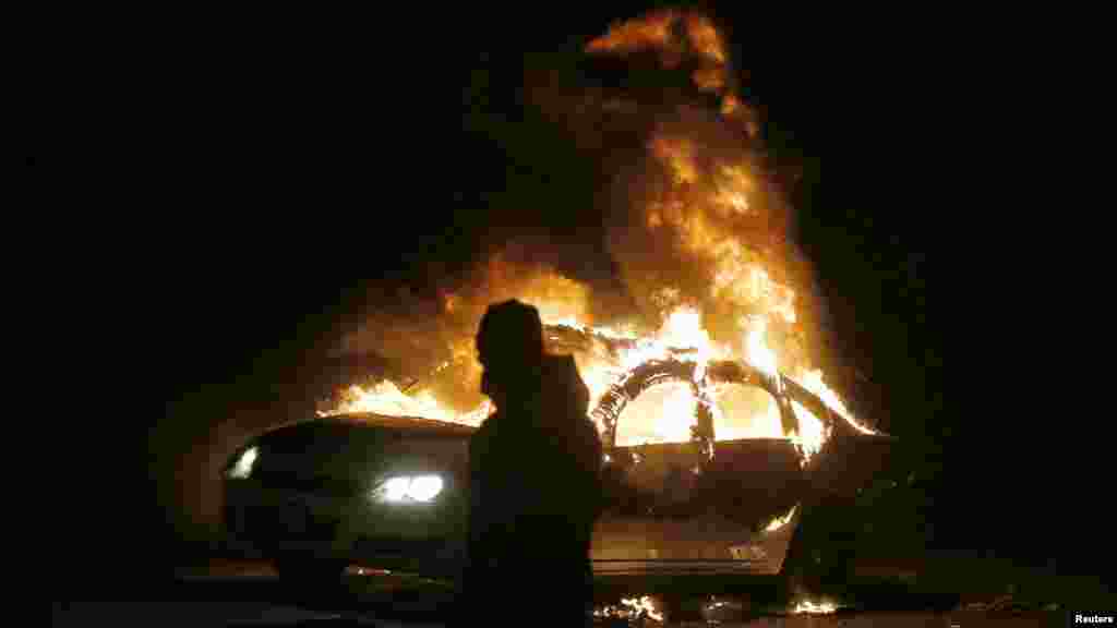 A car burns on the street after a grand jury returned no indictment in the shooting of Michael Brown in Ferguson, Missouri, Nov. 24, 2014.