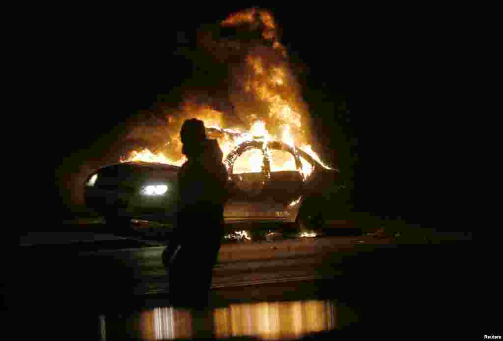 A car burns on the street after a grand jury returned no indictment in the shooting of Michael Brown in Ferguson, Missouri, Nov. 24, 2014.