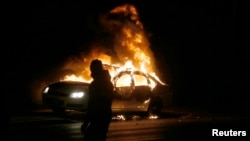 A car burns on the street after a grand jury returned no indictment in the shooting of Michael Brown in Ferguson, Missouri, Nov. 24, 2014.