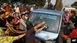 Bangladeshi garment workers vandalize a vehicle during a protest in Savar, on the outskirts of Dhaka, Bangladesh, Jan. 9, 2019. 