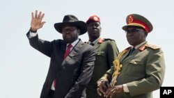 FILE - South Sudan's President Salva Kiir, left, accompanied by army chief of staff Paul Malong, right, waves during an independence day ceremony in the capital Juba, South Sudan.