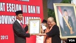 Gubernur Jakarta Joko Widodo menerima penghargaan dari Jaya Suprana dari Museum Rekor Indonesia (MURI) berkat upacara pelantikan massal camat dan lurah. (VOA/Iris Gera)