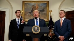 美国总统川普在白宫提出一项减少移民人数的立法提案，国会参议员汤姆·科顿（左）和戴维·帕度站立在两边。（2017年8月2日）