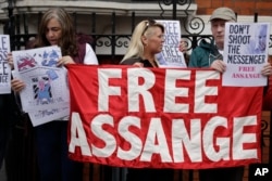 Supporters of WikiLeaks founder Julian Assange stand outside the Ecuadorean Embassy as Assange addresses the media, in London, May 19, 2017.