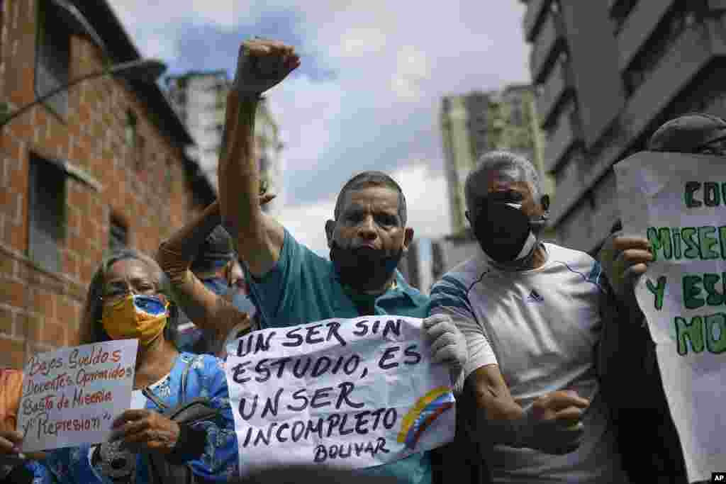 A man shouts slogans as he holds the Spanish quote: "An uneducated person is an incomplete person. Bolivar." at a demonstration by teachers demanding better salaries in Caracas, Venezuela, on World Teachers' Day, Monday, Oct. 5, 2020, amid the COVID-19 pandemic. (AP Photo/Matias Delacroix)