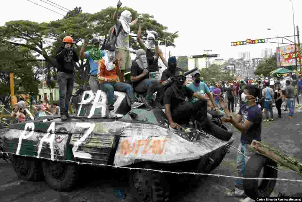 Apoiantes da oposição sobem em tanque durante um protesto contra o governo de Nicolas Maduro, em San Cristobal, cerca de 660 a sudoeste de Caracas, 19 Fevereiro de 2014.