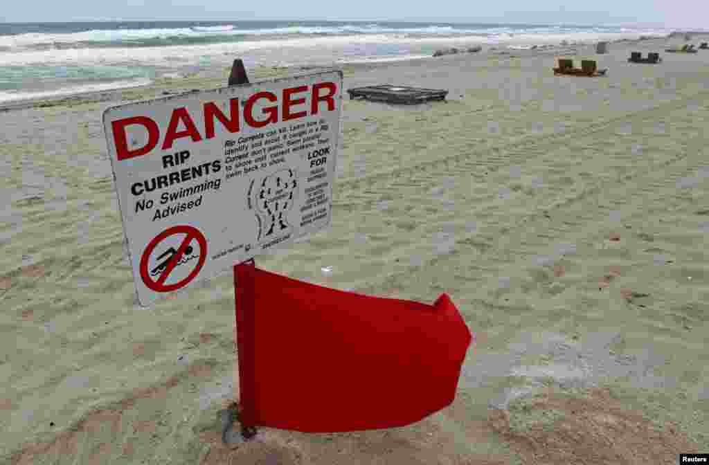 A red flag flies after lifeguards closed the area for swimming because of dangerous rip currents, as winds from Hurricane Sandy began to affect weather in Deerfield Beach, Florida, October 25, 2012.