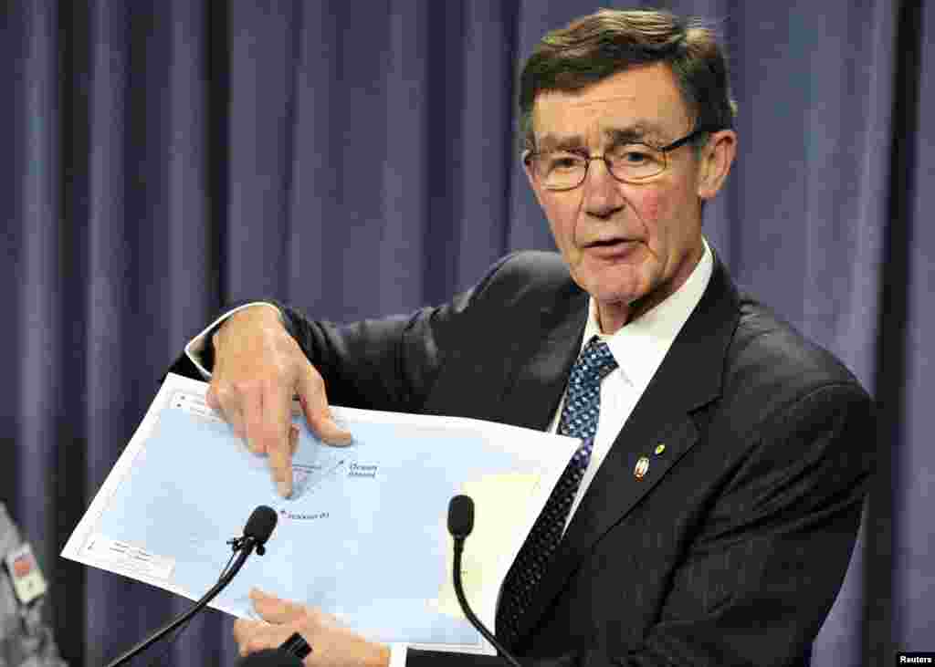 Angus Houston, head of the Australian agency coordinating the search for missing Malaysian Airlines Flight MH370, points to a map as he speaks during a news conference in Perth, April 7, 2014.