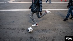 Un migrant de Gambie joue au football à la gare centrale de Milan à Milan, Italie, 12 octobre 2016.