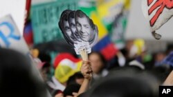 Partidarios del ex-presidente de Ecuador, Rafael Correa, levantan imágenes de su rostro mientras protestan afuera de la Asamblea Nacional en Quito, un intento por enjuiciar al ex-gobernante. Junio 14 de 2018.
