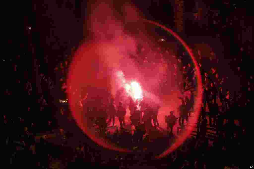 Catalan pro-independence demonstrators and Barcelona supporters light flares as they gather outside the Camp Nou stadium ahead of a Spanish La Liga soccer match between Barcelona and Real Madrid in Barcelona, Spain.