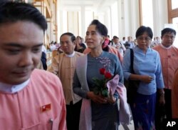 Myanmar opposition leader Aung San Suu Kyi, center, walks upon arrival to attend a regular session of lower house at parliament Monday, Nov. 16, 2015.