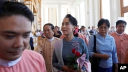 Myanmar opposition leader Aung San Suu Kyi, center, arrives to attend a regular session of the lower house of parliament, Nov. 16, 2015.