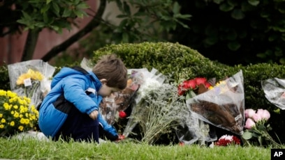 Một cậu bé đặt hoa tưởng niệm các nạn nhân hôm 28/10.