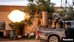 A fighter of the Kurdish People's Protection Units (YPG) fires an anti-aircraft weapon from Tel Tawil village in the direction of Islamic State fighters positioned in the countryside of the town of Tel Tamr. U.S. Special Ops will assist and advise indigenous fighters.