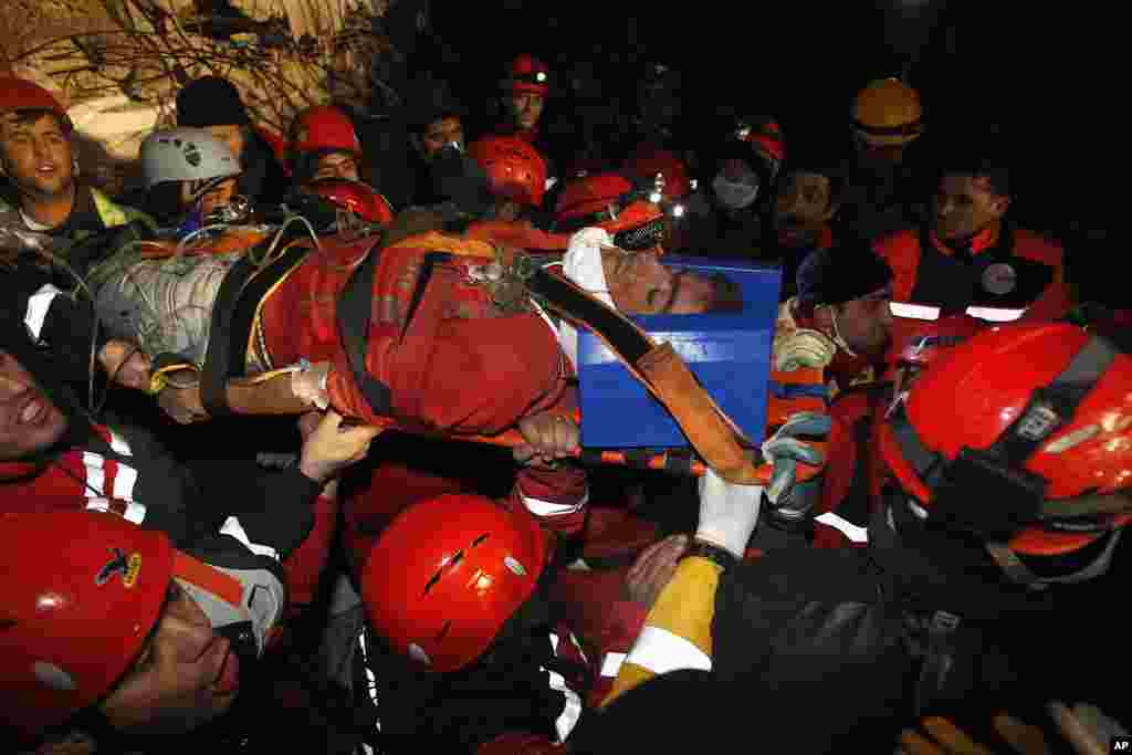 Rescue workers carry Imdat, 18, from a collapsed building after surviving for more than 100 hours, in Ercis, near the eastern Turkish city of Van, October 27, 2011. (Reuters)
