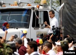 FILE - Venezuelan opposition leader Juan Guaido, whom many nations have recognized as the country's rightful interim ruler, stands on a truck carrying humanitarian aid for Venezuela, in Cucuta, Colombia, Feb. 23, 2019.