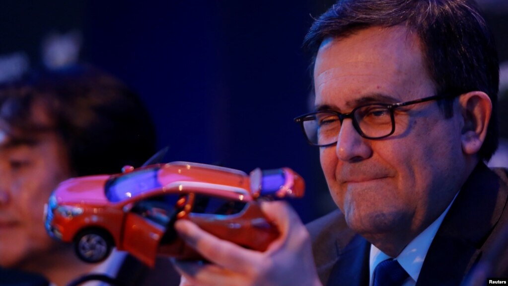 FILE - Mexico's Economy Minister Ildefonso Guajardo holds the model of a car during a news conference to announce the new plant of JAC Motors in Mexico City, Feb. 1, 2017.