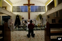 A person prays in Our Lady of Fatima Church in Poza Rica, Veracruz state, Mexico, Sept. 20, 2016. Two of the church's priests were found dead Monday, and were last seen Sunday. Their bullet-ridden bodies were found on a roadside.