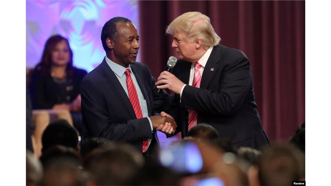 FILE - Donald Trump shakes hands with Ben Carson as he attends a church service in Detroit, Michigan, Sept. 3, 2016.