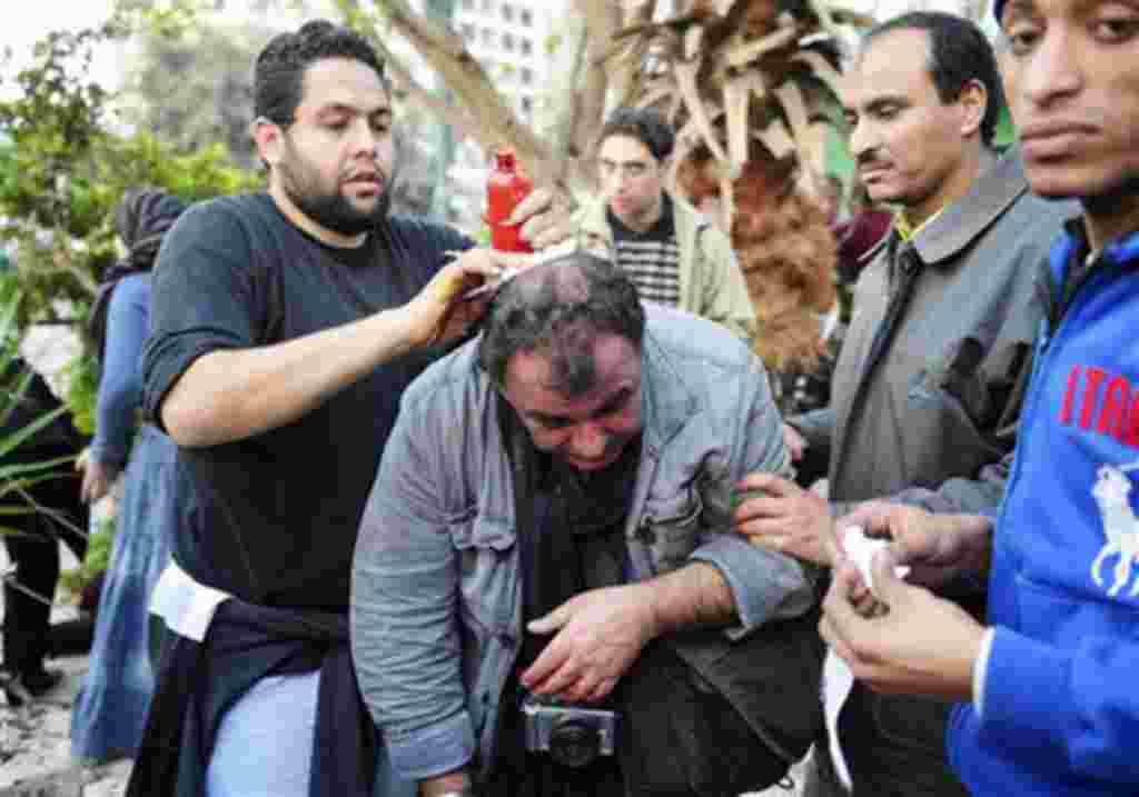 El fotoperiodista francés Alfred Yaghobzadeh amenazado por manifestantes anti-gobierno, en la plaza central de Tahrir, El Cairo.