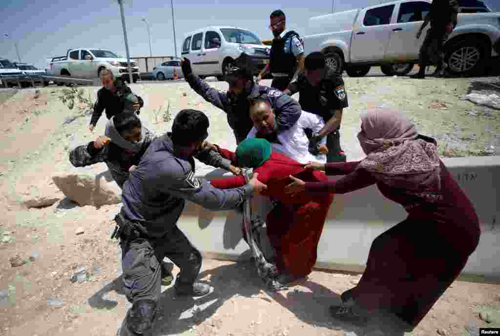 Israeli policemen detain Palestinians in the Bedouin village of al-Khan al-Ahmar near Jericho in the occupied West Bank.