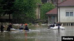 A rescue team makes its way in boats after flooding in in the Bosnian town of Maglaj, May 16, 2014. 