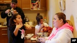 In this Jan. 9, 2018 photo, Enghie Melendez sits with her daughters Lidia, left, Alondra, and husband Fernando Moyet in their hotel kitchen in the Brooklyn borough of New York. 