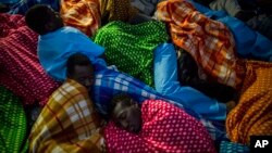 FILE - Refugees and migrants rest aboard the Golfo Azurro, a Spanish rescue ship, after being found off the Libyan coast, early in the morning, Feb. 23, 2017.