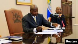 Uganda President Yoweri Museveni signs an anti-homosexual bill into law at the state house in Entebbe, 36 km south west of capital Kampala February 24, 2014. 