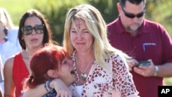 Parents wait for news after a report of a shooting at Marjory Stoneman Douglas High School in Parkland, Fla., Feb. 14, 2018. 