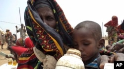 Une mère étanche la soif de son enfant mal nourri en attendant des livraisons de nourriture dans un centre de santé dans la région somalienne éloignée de la sécheresse de l'Est de l'Ethiopie, également connue sous le nom d'Ogaden, Ethiopie, 9 juillet 2011. 