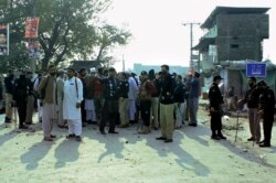 Police officers control an angry crowd protesting against a mentally unstable man accused of blasphemy, in Mandani, an area of Charsadda district, Pakistan, Nov. 29, 2021.