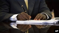 Uganda's President Yoweri Museveni signs a new anti-gay bill that sets harsh penalties for homosexual sex, in Entebbe, Uganda, Feb. 24, 2014.
