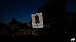 FILE - A poster depicting Haiti's President Jovenel Moise, who was assassinated in July, towers over a road in Port-au-Prince, Haiti, Sept. 28, 2021.