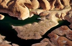 Rumah perahu berkemah di pantai di perairan dangkal di ngarai di Lake Powell dekat Page, Arizona, 26 Mei 2015. (Foto: REUTERS/Rick Wilking)