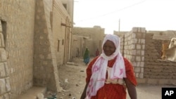 A young woman wears a headscarf in accordance with the directives of Islamist group Ansar Dine, which is seeking to impose Shariah law on Mali's Tuareg-occupied north, as she walks along an alley in Timbuktu, Mali. 