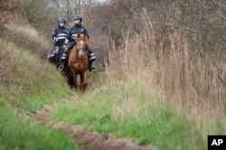 Police officers on horses patrol the dunes on the French-Belgian border in Adinkerke, Belgium, Feb. 24, 2016.