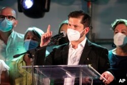 Presidential candidate Gabriel Boric, of the political alliance 'Apruebo Dignidad,' or I Approve of Dignity, speaks to supporters after polls closed and partial results were announced at his election day headquarters in Santiago, Nov. 21, 2021.