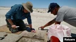 Archaeologist Daron Duke (L) and colleague Michael Shane work in this undated handout photo released on October 11, 2021 at an ancient hearth dating to 12,300 years ago at the Wishbone site in Great Salt Lake Desert in northern Utah. (Sarah K. Rice/Handout via REUTERS) 