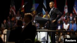 U.S. President Barack Obama playfully mimics the arms-akimbo stance of a young woman who asked a question during a town hall session at the Young African Leaders Initiative (YALI) Mandela Washington Fellowship Presidential Summit in Washington, Aug. 3, 20